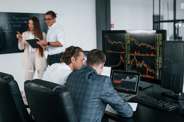 attention-details-team-stockbrokers-works-modern-office-with-many-display-screens_146671-52480 (1) (1)